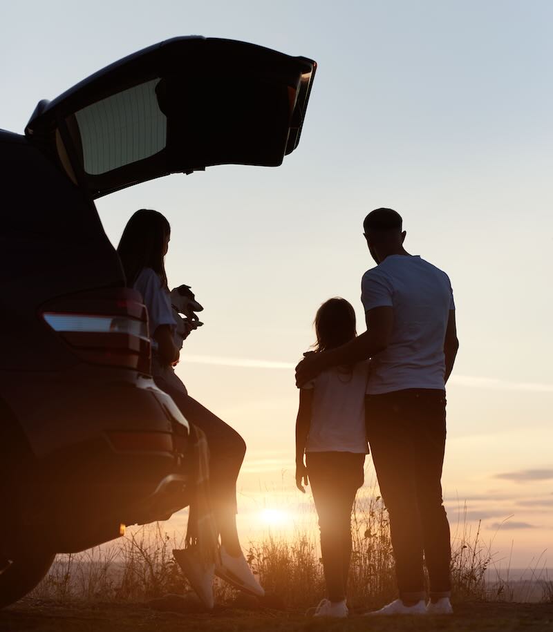 Silhouette of the family of three enjoying the sunset